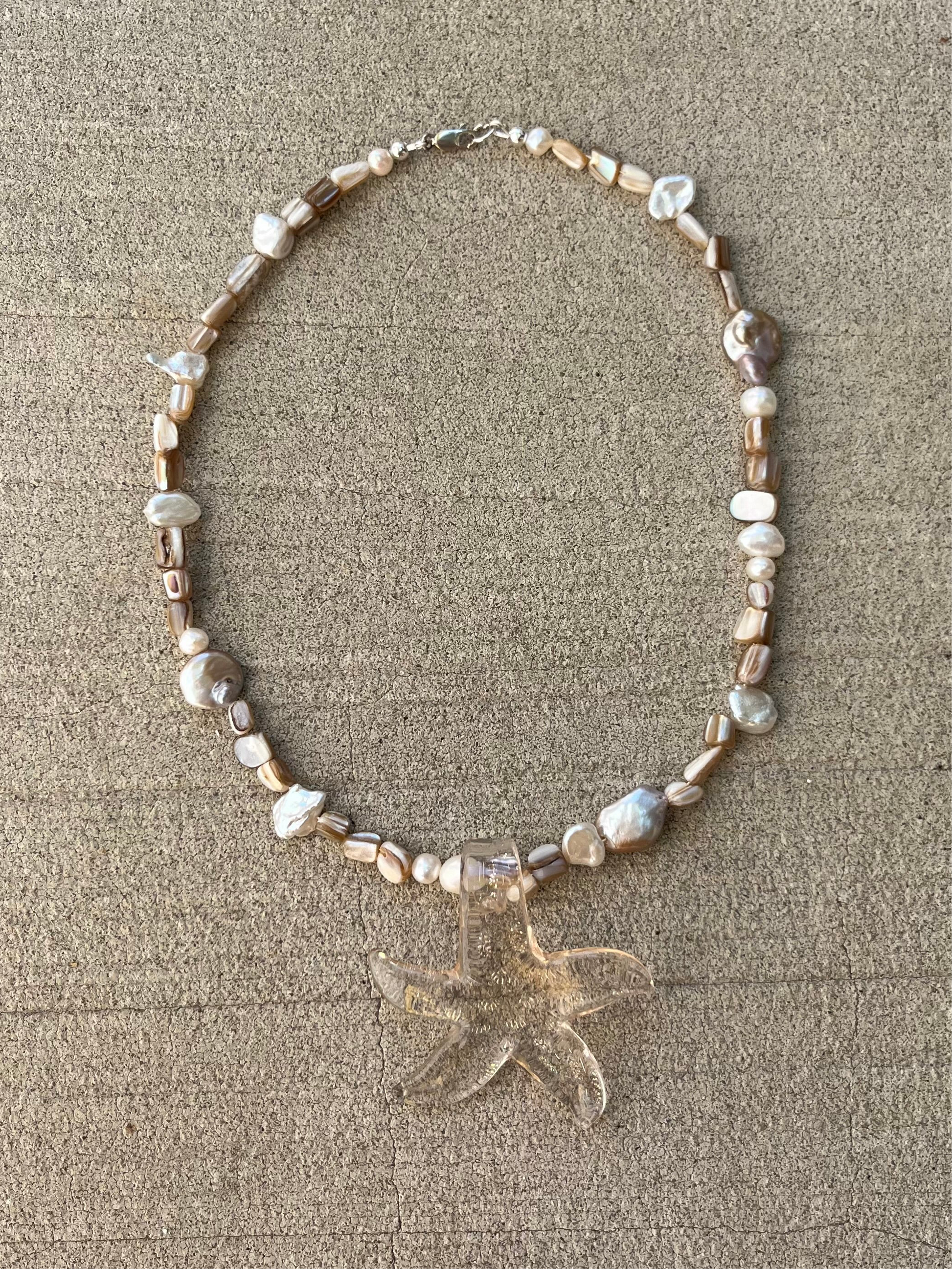 Mother of Pearl shell beads
Pearly pink freshwater pearls 
second hand sourced hand blown glass starfish pendant 
925 sterling silver findings
Chunky statement necklace 
Beachy boho modern eclectic 